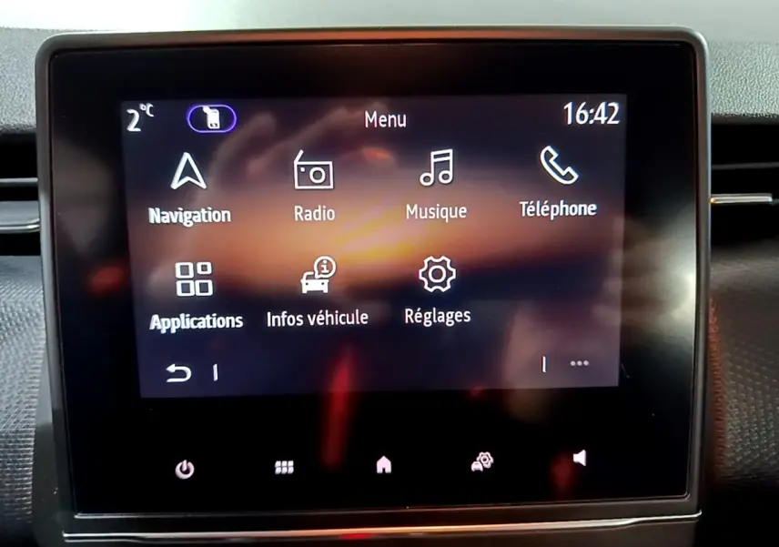 Écran tactile central de la Renault Clio Business bleu affichant le menu principal avec navigation et radio.