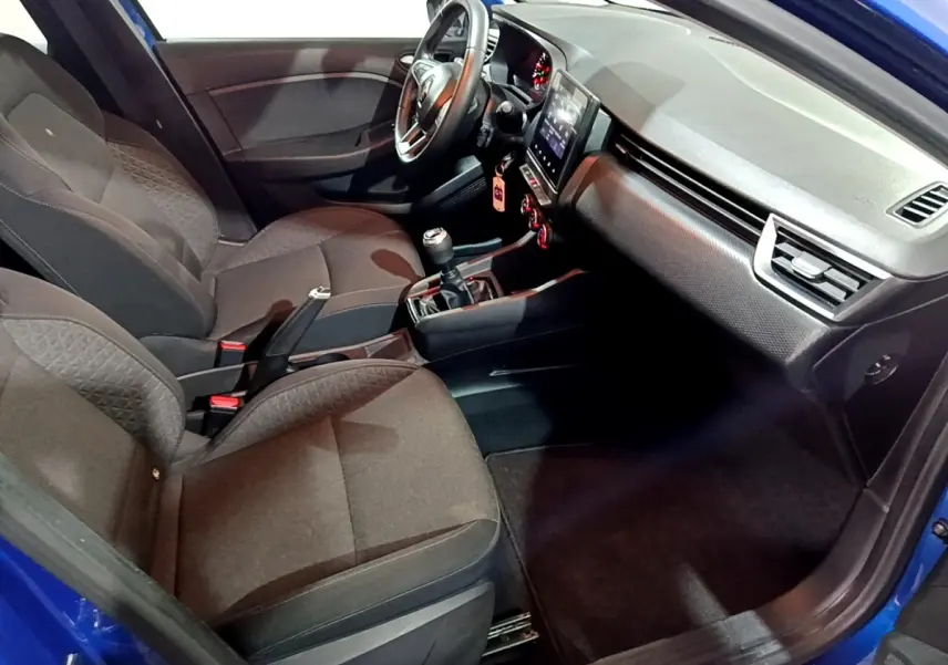 Intérieur de la Renault Clio Business bleu, vue côté conducteur, volant cuir multifonctions et écran tactile central visible.