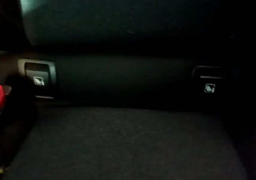 Gros plan sur la banquette arrière noire de la Renault Clio Business, montrant les leviers de rabattement des sièges.