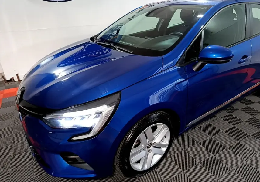 Renault Clio Business bleu vue 3/4 avant droit, phares LED allumés et jantes alliage visibles.