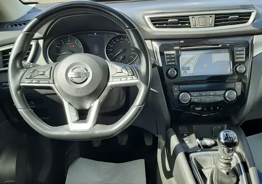 Vue intérieure du tableau de bord et volant noir du Nissan Qashqai 2018 avec boîte manuelle et écran tactile central.