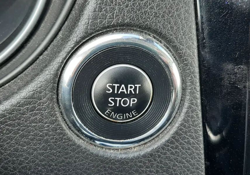 Gros plan sur le bouton Start Stop Engine entouré de chrome dans l’habitacle noir texturé du Nissan Qashqai 2018.