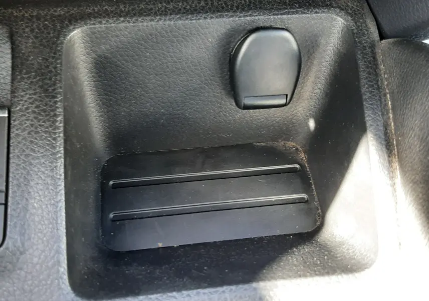 Gros plan sur le rangement central noir avec prise 12V dans l’habitacle du Nissan Qashqai marron métal 2018.
