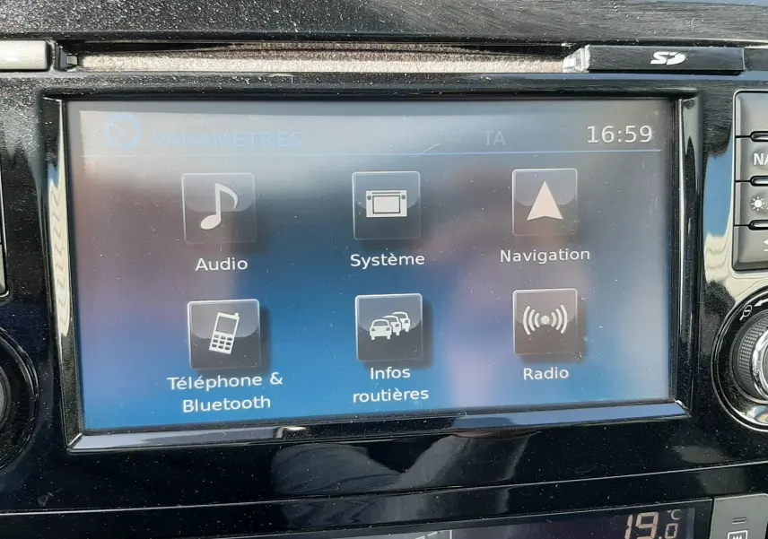 Écran tactile central du Nissan Qashqai 2018 montrant les options audio, navigation et Bluetooth, avec commandes climatisation.