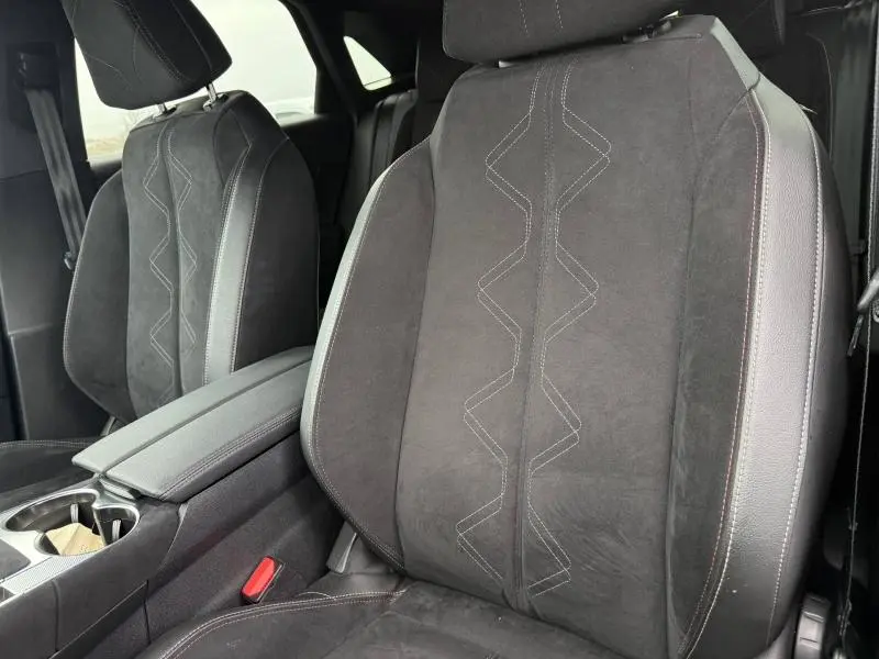 Gros plan sur les sièges avant en cuir et alcantara noirs du DS7 E-TENSE 2024, avec surpiqûres décoratives en zigzag.