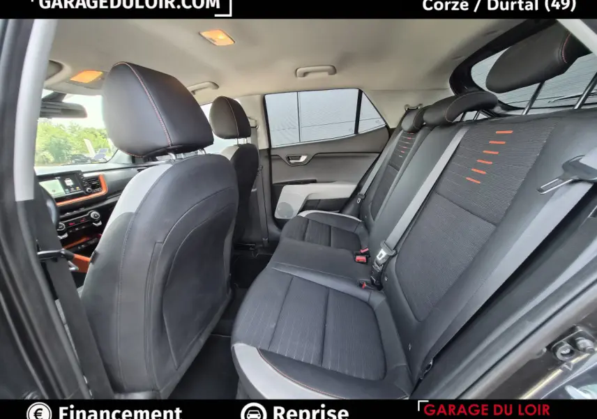 Vue intérieure côté droit montrant la banquette arrière noire avec surpiqûres orange du Kia Stonic 2019.