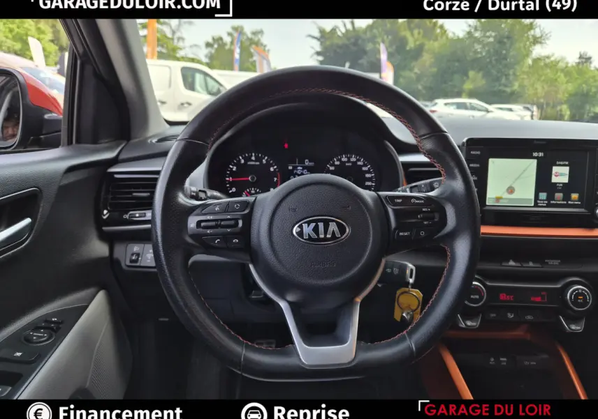 Vue intérieure centrée sur le volant cuir noir avec surpiqûres orange du Kia Stonic 2019, tableau de bord et écran tactile visibles.