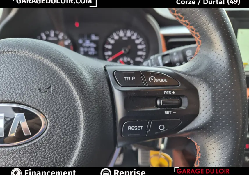 Gros plan sur le volant cuir noir avec surpiqûres orange du Kia Stonic 2019, montrant les commandes de régulateur de vitesse.