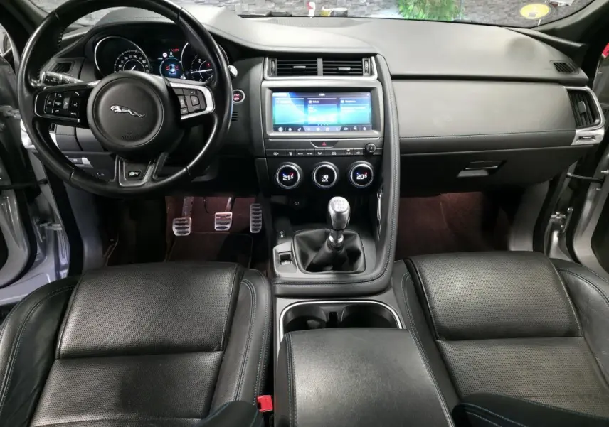 Vue intérieure frontale du tableau de bord noir et volant cuir multifonction de la Jaguar E-PACE D150 AWD 2019.