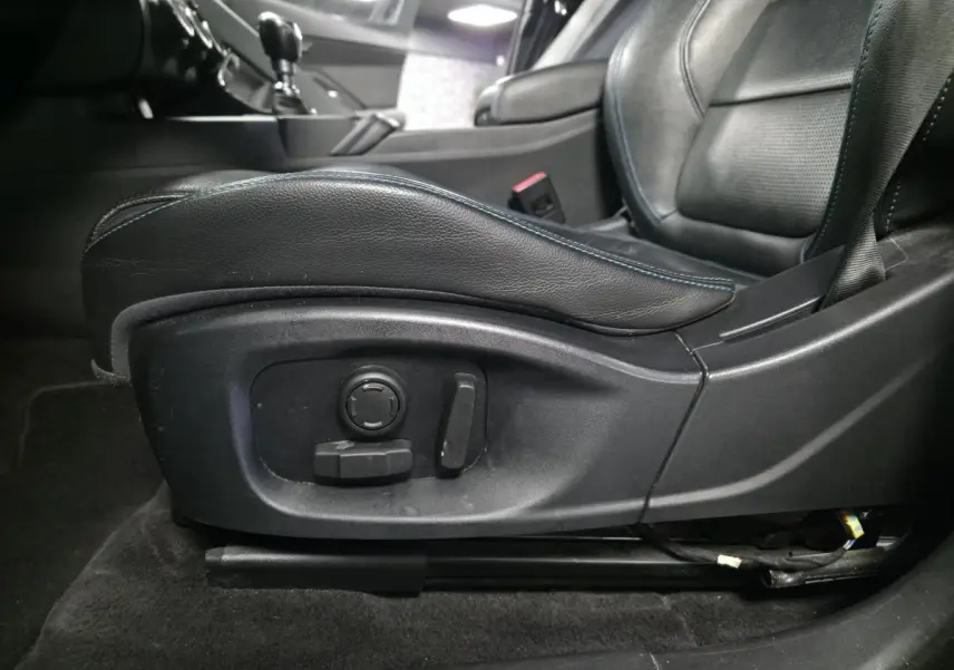 Gros plan sur le siège avant conducteur en cuir noir avec réglages électriques, intérieur du Jaguar E-PACE D150 gris 2019.