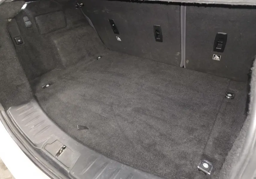 Coffre spacieux et propre du Jaguar E-PACE D150 AWD R-Dynamic S, vue intérieure avec moquette noire.
