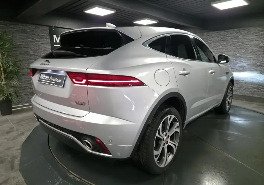 Vue 3/4 arrière droite d’un Jaguar E-PACE gris métallisé avec feux arrière LED et jantes 20 pouces à 6 branches doubles.