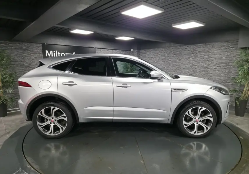 Jaguar E-PACE gris vue de profil côté gauche, avec jantes 20 pouces et vitrage arrière fumé.