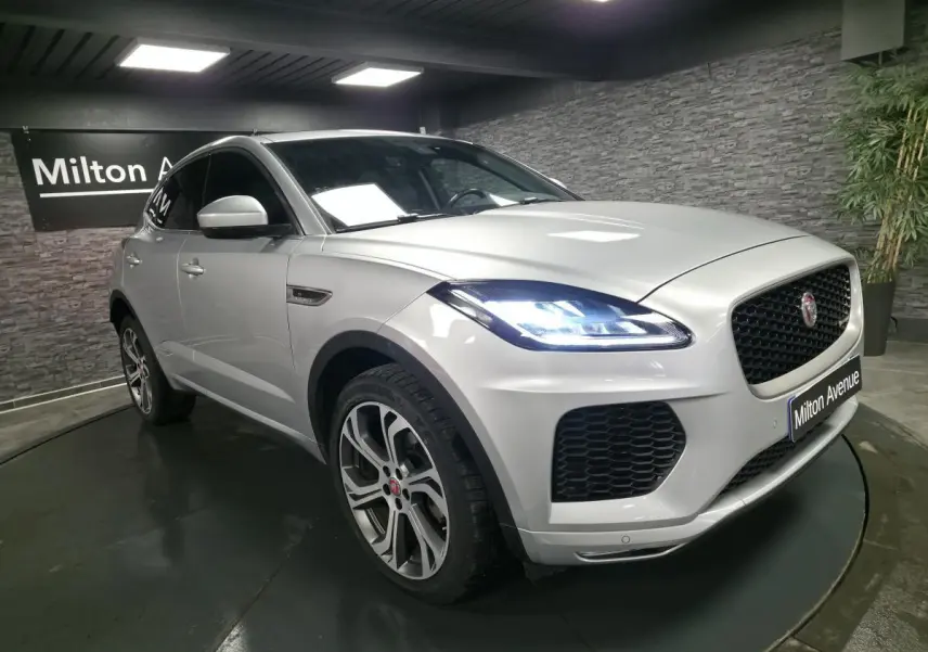Jaguar E-PACE gris vue 3/4 avant droit avec phares LED allumés et jantes 20 pouces style 6014.