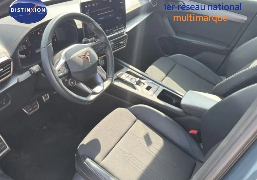 Vue intérieure côté conducteur du CUPRA Formentor gris magnétique, mettant en valeur le volant multifonction et la console centrale moderne.