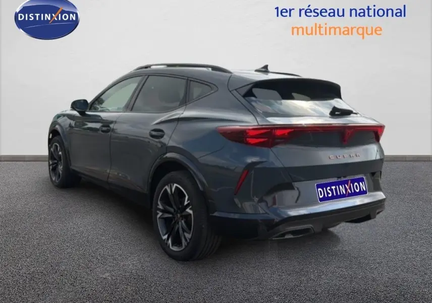 Vue 3/4 arrière droite d’un CUPRA Formentor gris magnétique métal avec jantes noires et feux arrière allumés.