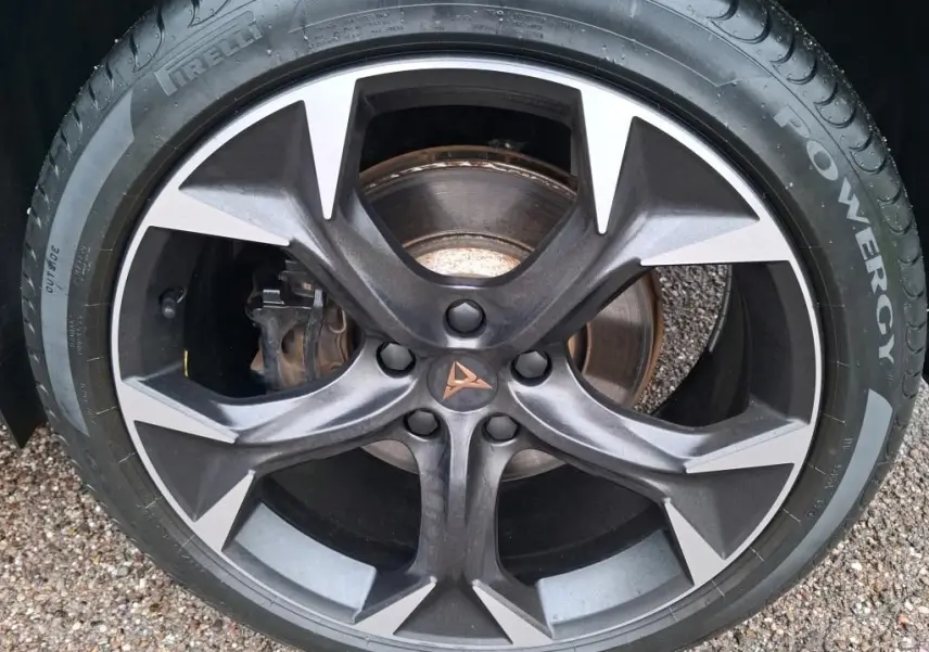 Gros plan sur la jante noire et argentée avec logo CUPRA au centre, montée sur pneu Pirelli Powergy.