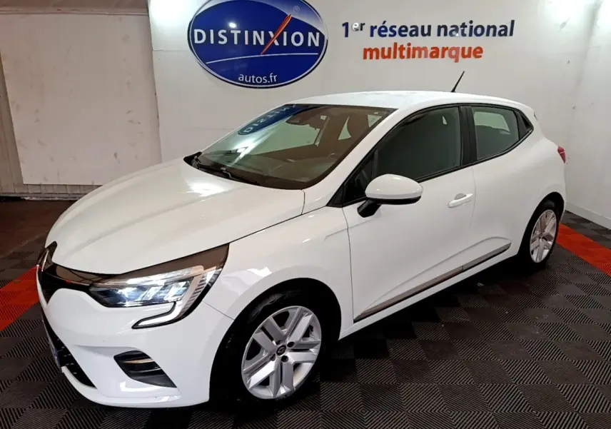 Renault Clio Business TCe 100 blanche vue 3/4 avant droit, avec phares LED allumés dans un showroom.
