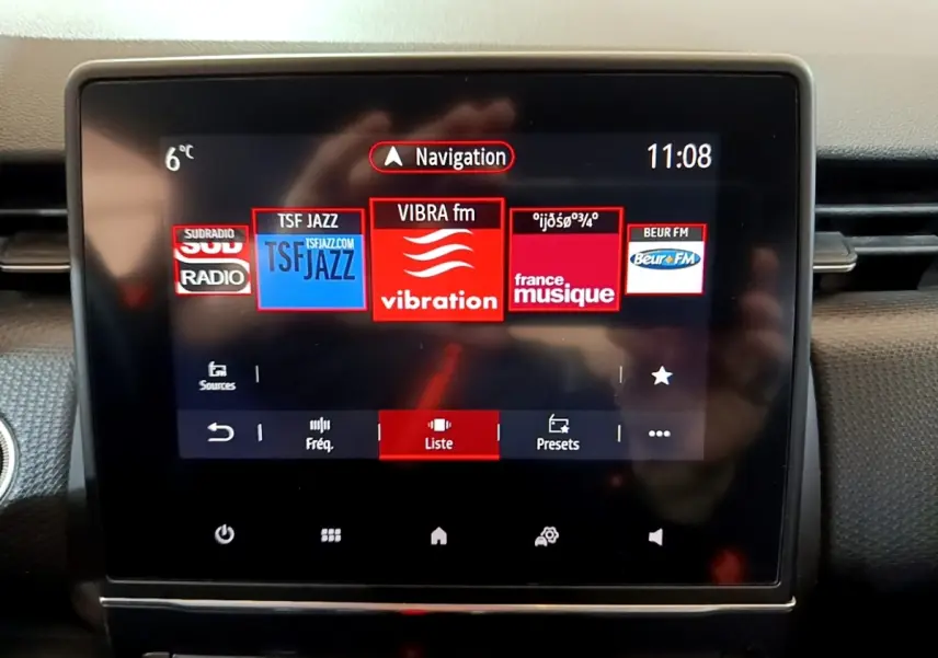 Écran tactile central de la Renault Clio Business TCe 100 blanc, affichant les stations radio et la navigation.