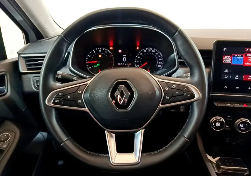 Vue rapprochée du volant en cuir synthétique noir de la Renault Clio Business TCe 100, avec tableau de bord et écran tactile.