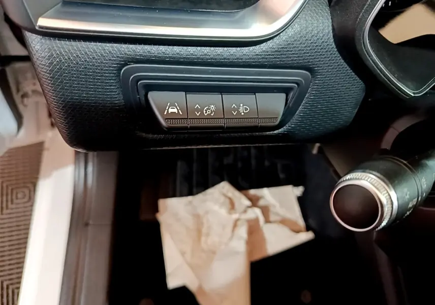 Vue intérieure du tableau de bord côté gauche de la Renault Clio blanche, avec commandes d’assistance à la conduite visibles.