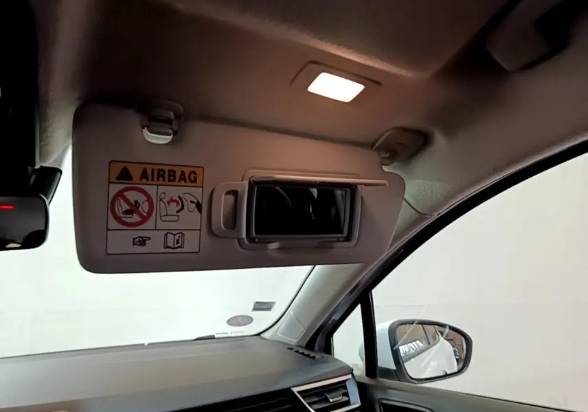 Intérieur de Renault Clio Business blanc 2020, vue côté droit sur pare-soleil avec miroir et avertissement airbag.