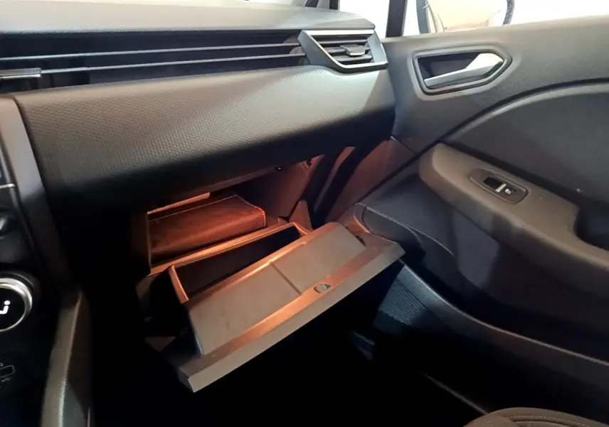 Vue intérieure côté passager de la Renault Clio Business TCe 100 2020, boîte manuelle, avec boîte à gants ouverte et tableau de bord noir.