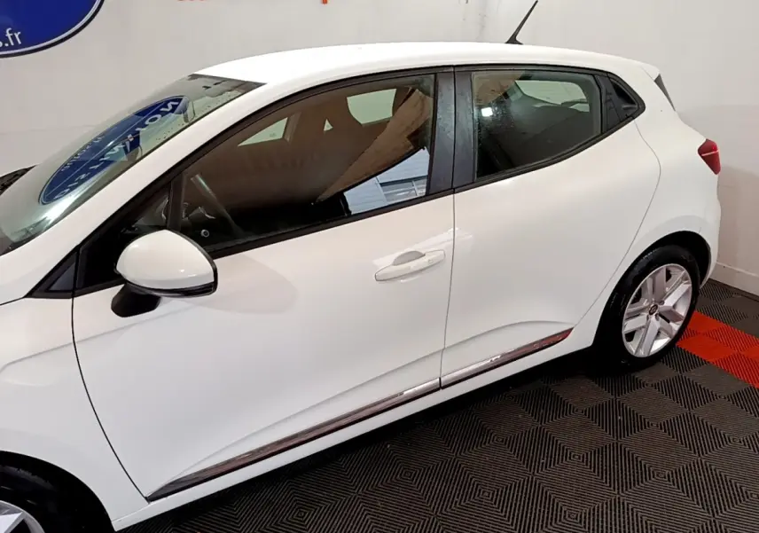 Profil côté gauche d'une Renault Clio Business TCe 100 blanche de 2020, avec jantes alliage et rétroviseur blanc.