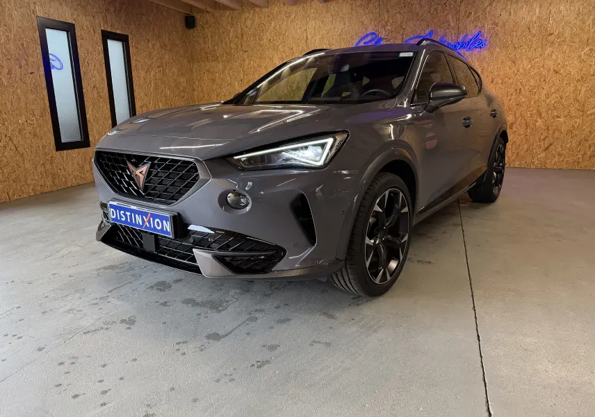 Vue 3/4 avant droite d'une CUPRA Formentor gris métallisé 2023 avec calandre noire et jantes alliage noires.