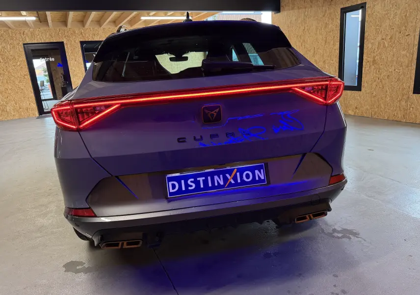 Vue arrière du CUPRA Formentor gris 2023 avec feux LED allumés et double sortie d’échappement rectangulaire.