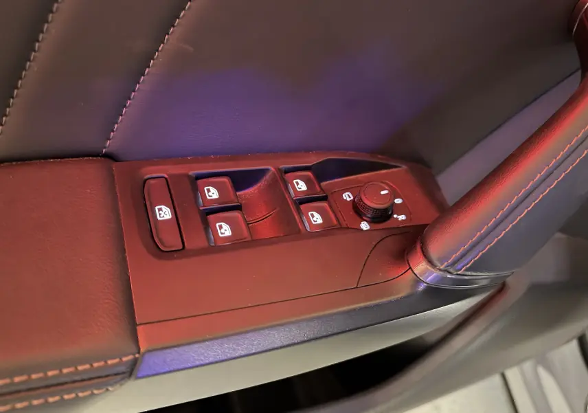 Gros plan sur les commandes des vitres électriques et rétroviseurs côté conducteur d’une CUPRA Formentor gris 2023.