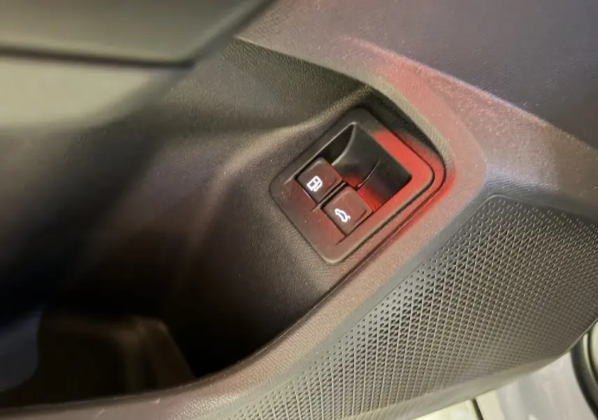 Détail des boutons d’ouverture de la trappe à carburant et du coffre sur la porte intérieure noire du CUPRA Formentor 1.4 Hybrid 245 VZ.