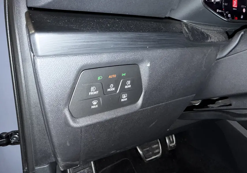 Vue intérieure côté gauche du tableau de bord gris foncé de la CUPRA Formentor 1.4 Hybrid avec commandes d’éclairage et pédales visibles.