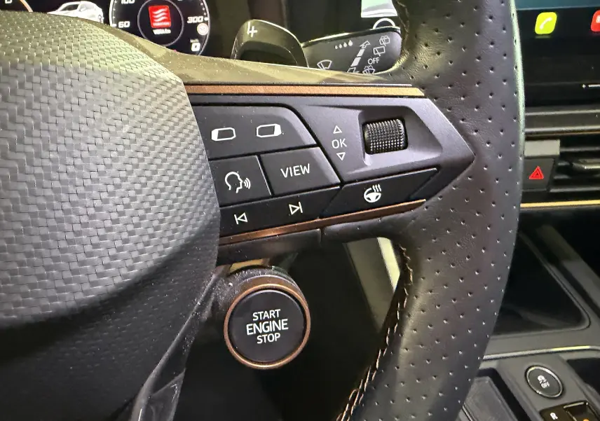 Gros plan sur le volant perforé noir de la CUPRA Formentor 1.4 Hybrid 245 VZ avec boutons multifonctions et bouton start/stop visible.
