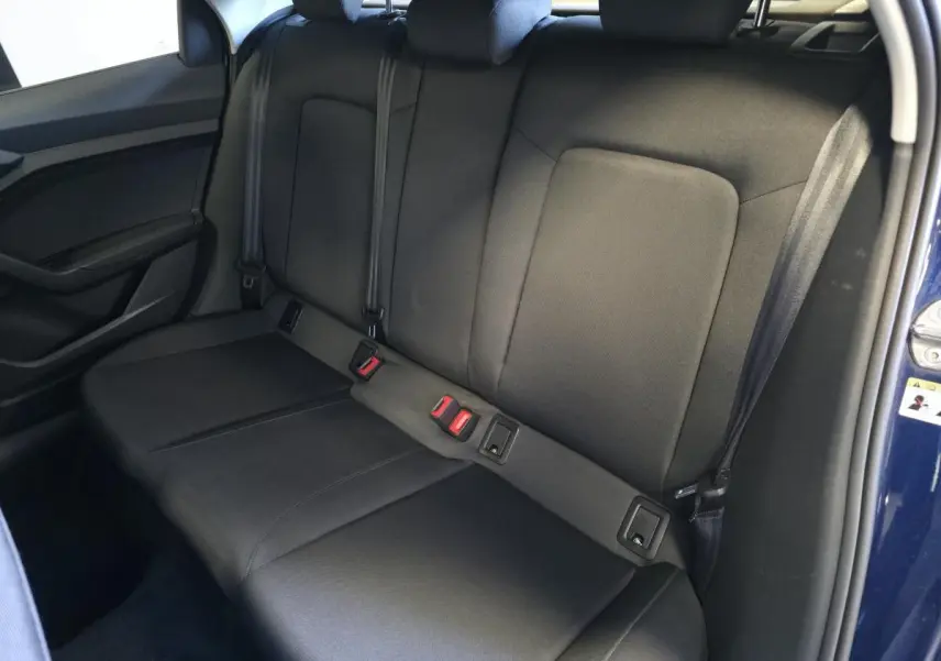 Vue latérale de la banquette arrière noire en tissu Novum de l'Audi A1 Sportback 2024 bleu, avec ceintures et appuie-têtes.