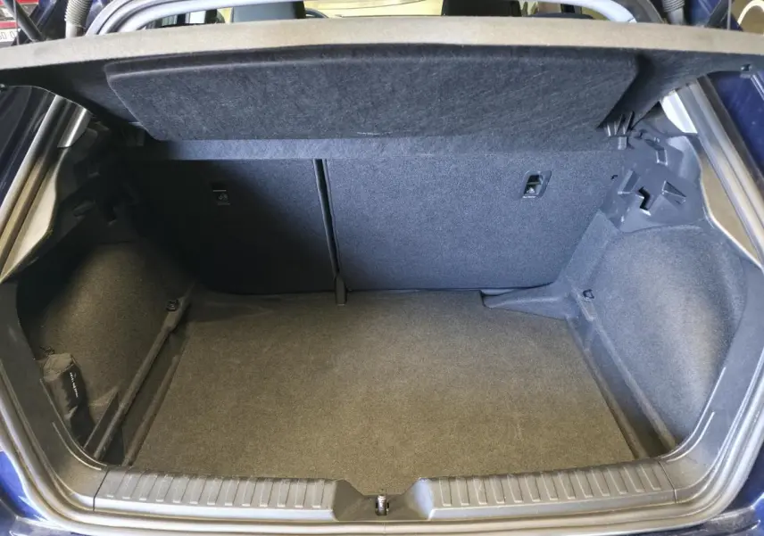 Coffre ouvert vu de l'arrière d'une Audi A1 Sportback bleu, montrant un espace de chargement propre et spacieux.