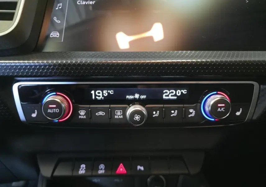 Panneau de climatisation automatique bi-zone de l’Audi A1 Sportback 2024 avec réglages numériques et boutons rotatifs colorés.