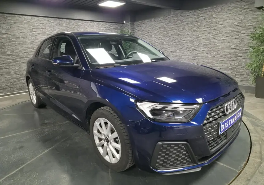 Audi A1 Sportback bleu métallisé vue 3/4 avant droit, calandre noire et jantes alu 16 pouces visibles.