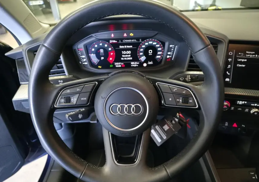 Vue rapprochée du volant cuir multifonctions noir et du tableau de bord digital de l'Audi A1 Sportback 2024.