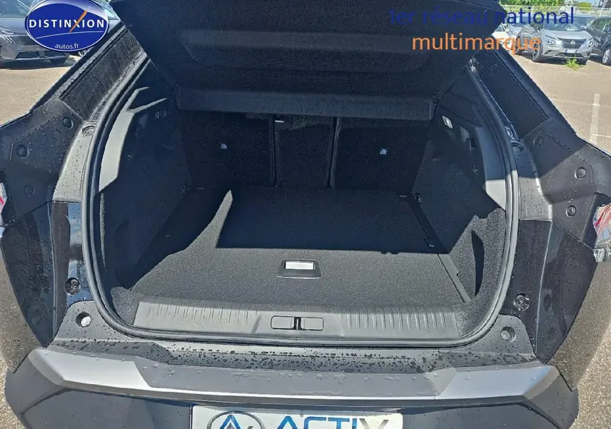 Coffre ouvert vu de l'arrière d'un Peugeot 3008 noir 2025 avec hayon et intérieur de coffre spacieux.