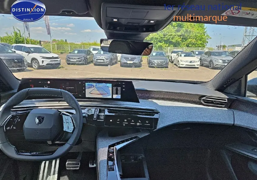 Vue intérieure avant du Peugeot 3008 noir 2025, volant multifonction et écran tactile large avec caméra de recul affichée.