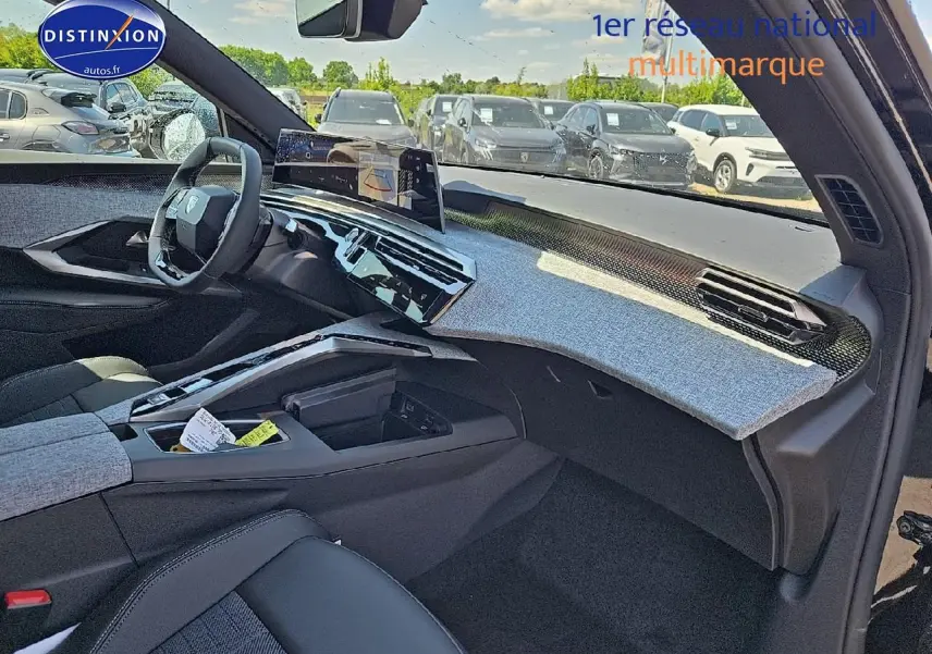 Vue intérieure côté passager du Peugeot 3008 hybride 2025, tableau de bord avec habillage gris et volant cuir noir.