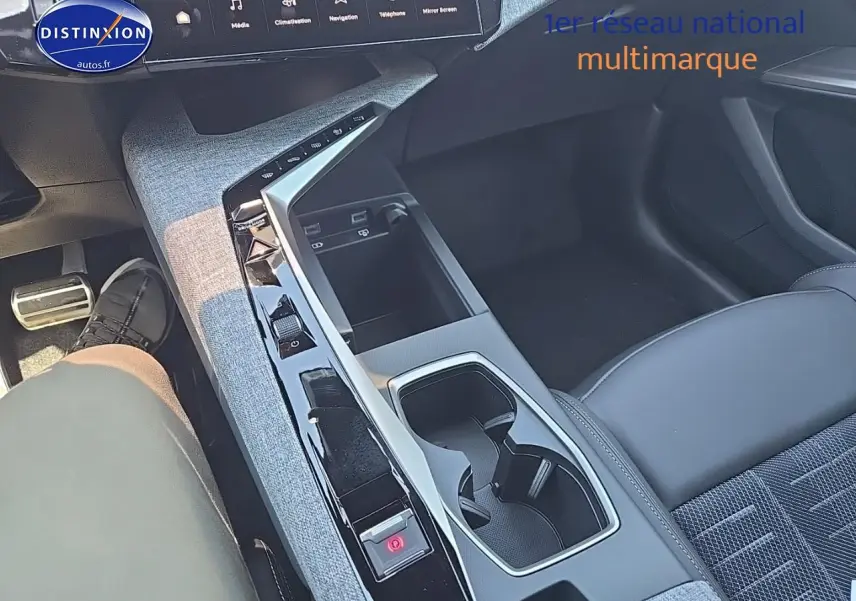 Vue intérieure centrée sur la console centrale et l'accoudoir avant du Peugeot 3008 noir hybride 2025.
