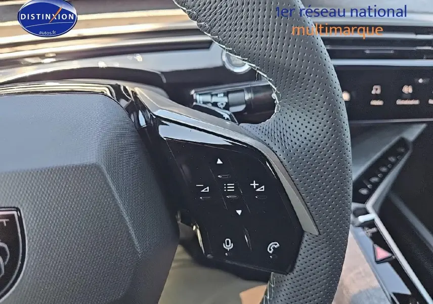 Gros plan sur le volant cuir perforé côté gauche du Peugeot 3008 noir hybride avec commandes multifonctions intégrées.