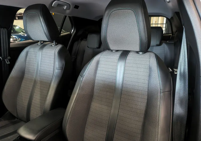 Gros plan sur les sièges avant en tissu gris et cuir noir du Peugeot 2008 PureTech 100 Allure 2021, intérieur spacieux.