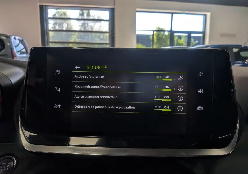 Écran tactile central du Peugeot 2008 gris Artense montrant les réglages de sécurité activés, vue intérieure frontale.