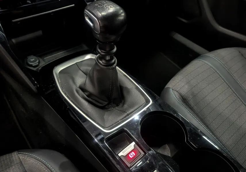 Gros plan sur le levier de vitesse manuel noir et la console centrale du Peugeot 2008 gris Artense, avec siège tissu visible.
