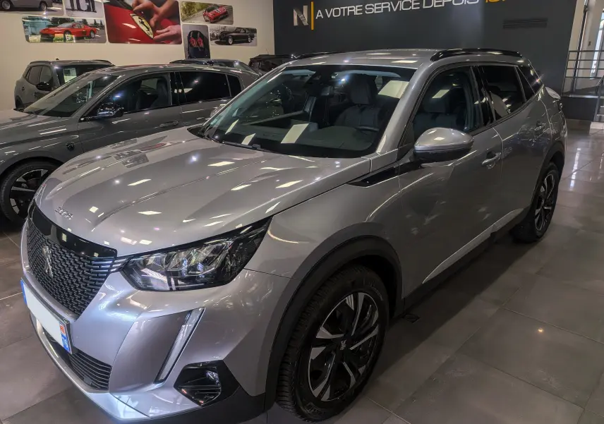 Peugeot 2008 gris Artense en 3/4 avant droit, mettant en valeur sa calandre distinctive et ses jantes bi-ton.