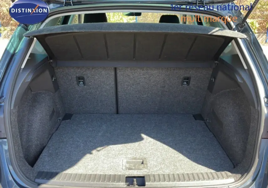 Coffre ouvert vu de l'arrière d'un SEAT Arona gris Magnetic Metal avec toit noir, intérieur du coffre en tissu gris.