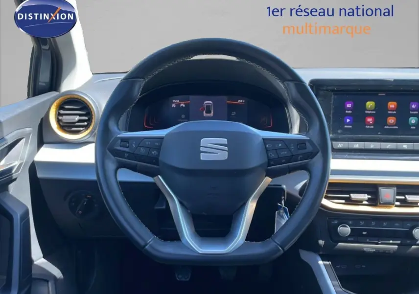 Vue frontale du poste de conduite du SEAT Arona gris magnetic metal avec volant multifonction et écran tactile central.